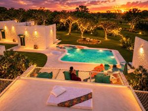 a woman sitting in a chair next to a swimming pool at Epic Wild Wilpattu in Nochchiyagama