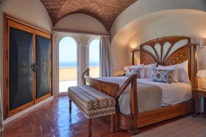 a bedroom with a bed and a balcony with the ocean at Hotel Fortaleza do Guincho Relais & Châteaux in Cascais +55 photos