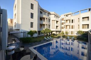 a swimming pool in front of a building at Farms Fintas - Family Only in Kuwait