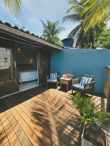 a patio with two chairs and a bed and a table at Pousada Ilha do Frade in Fernando de Noronha