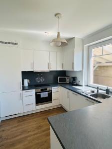 a kitchen with white cabinets and a black counter top at Emils Heidehaus in Soltau