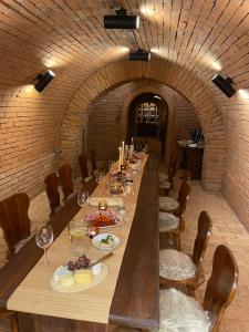 a long table with plates of food and wine glasses at Sommeliérka - ubytování & vinný sklep in Valtice