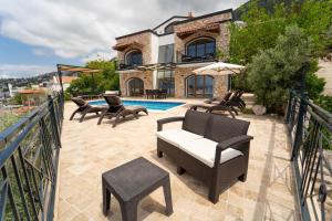 a patio with chairs and a pool in front of a house at Villa Meltem in Kalkan