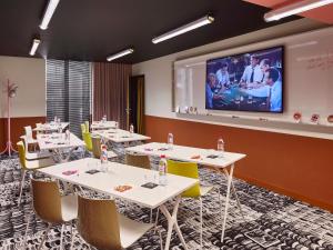 a conference room with tables and a large screen at Mama Shelter Lille in Lille
