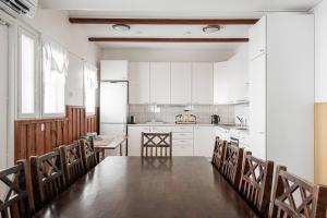 a kitchen with a table and chairs and white cabinets at CYV - A unique Villa on a Lake in Jämijärvi