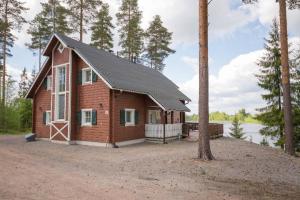 a cabin in the woods next to a lake at CYV - A unique Villa on a Lake in Jämijärvi