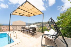 a house with a swimming pool and a patio with chairs at Villa Meltem in Kalkan