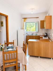 a kitchen and dining room with a table and a refrigerator at Olga Apartments in Kolónion
