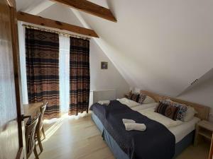 a bedroom with a large bed in a attic at Polanki10 Łebski Dworek u Anity in Nowęcin