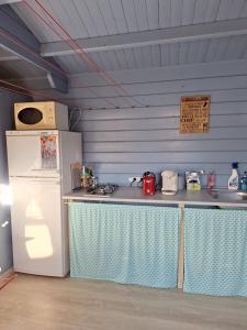 a kitchen with a counter with a refrigerator and a sink at Chambre d'Hôtes Les Bruyères in Cadouin
