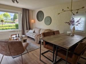 a living room with a table and a couch at Chalet in Berkhout, close to the beach in Berkhout