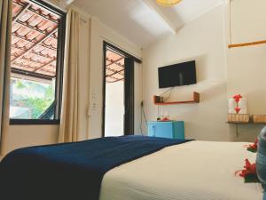 a bedroom with a bed and a tv on the wall at Pousada Ilha do Frade in Fernando de Noronha