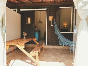 a porch with a wooden table and a bench at Pousada Ilha do Frade in Fernando de Noronha