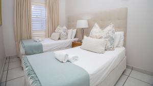 two twin beds in a room with a window at D3 Sea Lodge - by Stay in Umhlanga in Durban +42 photos