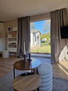 a living room with a table and a large window at Chalet in Berkhout, close to the beach in Berkhout