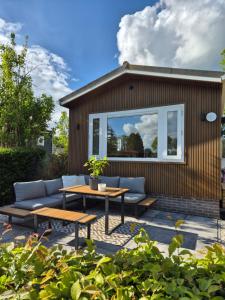 a patio with a couch and a table at Chalet in Berkhout, close to the beach in Berkhout