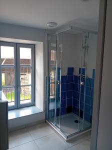 a glass shower in a bathroom with a window at ESCALE MORVANDELLE chambre 4 lits 2 salles de bain in Saint-Brisson