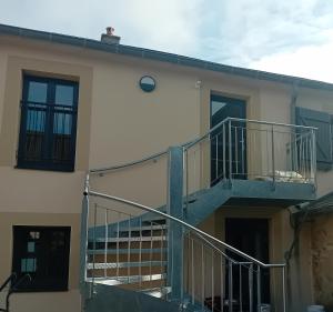 a man on the roof of a building with a staircase at ESCALE MORVANDELLE chambre 4 lits 2 salles de bain in Saint-Brisson