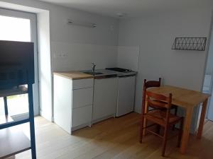 a kitchen with a table and a sink and a table and chair at ESCALE MORVANDELLE chambre 4 lits 2 salles de bain in Saint-Brisson