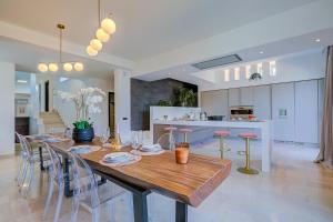 a dining room and kitchen with a wooden table and chairs at Lugano Lake View Villa with Private Pool in Lugano