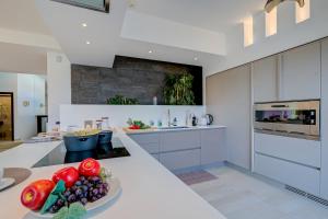 a kitchen with a plate of fruits and vegetables on a counter at Lugano Lake View Villa with Private Pool in Lugano