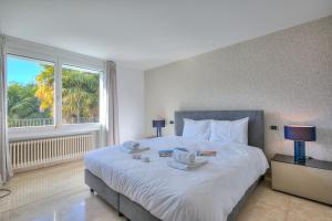 a bedroom with a large white bed with a window at Lugano Lake View Villa with Private Pool in Lugano