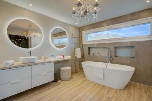 a bathroom with a tub and two sinks and a large window at Lugano Lake View Villa with Private Pool in Lugano +46 photos
