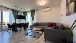 a living room with a couch and a table at Blu Riviera Deluxe in Ahtopol