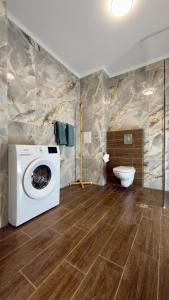 a bathroom with a washing machine and a toilet at Blu Riviera Deluxe in Ahtopol +12 photos