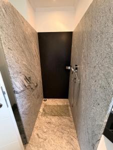 a bathroom with a shower with a stone wall at Ferienwohnung Auszeit Langsur in Langsur