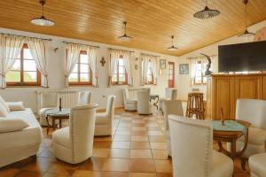 a living room with white furniture and a flat screen tv at Domačija Harmonija in Vremski Britof