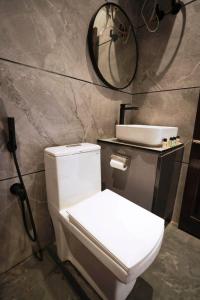 a bathroom with a white toilet and a mirror at L'Elegant Resort in Chail +51 photos