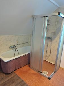 a bathroom with a shower and a bath tub at Bright and spacious home with good in Klepp