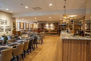 a restaurant with tables and chairs and a bar at Hotell Högland in Nässjö