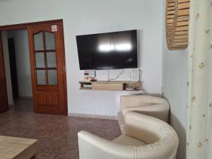 a living room with a flat screen tv on a wall at Apartamento Sevilla 3 in La Guardia