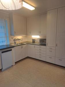 a kitchen with white cabinets and a sink at Bright and spacious home with good in Klepp