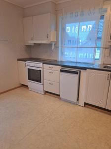 a kitchen with white appliances and a large window at Bright and spacious home with good in Klepp