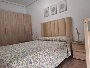 a bedroom with a bed and wooden cabinets at Apartamento Sevilla 3 in La Guardia +8 photos