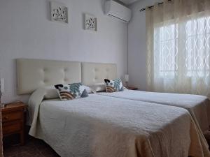 a bedroom with two beds and a window at Apartamento Sevilla 3 in La Guardia