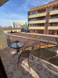 a balcony with a table and chair and a building at Vila Rubin in Eforie Nord