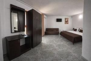 a hotel room with a bed and a couch at Vila Rubin in Eforie Nord