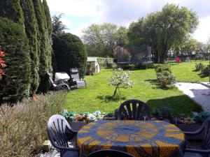a table and chairs in a backyard with a garden at Les Six Vallées in Ramillies +7 photos