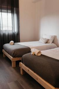 a bedroom with two beds with a teddy bear on the pillow at Aurega Vintage Bedrooms by Lethes Legacy in Ponte de Lima