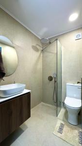 a bathroom with a sink and a toilet and a shower at Melinda’s cozy apartments in Plomari +12 photos