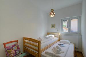 a small bedroom with two beds and a window at La Cà Da Brè - Garden House with Views - Happy Rentals in Lugano