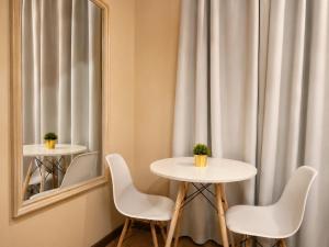 a table and chairs in a room with a mirror at Flats Morada do Jordão in Campos do Jordão