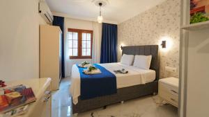 a bedroom with a bed with a blue blanket at Flower Apart 2 - Flower Hotel Patara in Gelemiş +38 photos