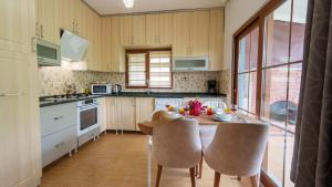 a kitchen with a table and chairs and a kitchen with a window at Flower Apart 2 - Flower Hotel Patara in Gelemiş