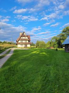 a large grassy field with a large house at Apartament II Chochołów 162c in Chochołów