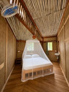 a bed in a room with a wooden ceiling at Stay Social Diani - Backpackers & Social Hub in Diani Beach
